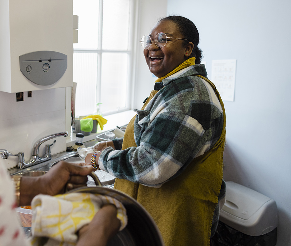 Photograph of a male and female couple washing up together and laughing